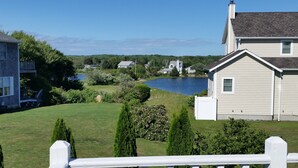 A residential area with a lake, houses, and a white fence. - Open Floor Plan, Family Friendly, Waterview Home  (Narragansett)