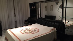 Ein Hotelzimmer mit Bett, Stuhl, Schreibtisch, Spiegel und Kleiderschrank.