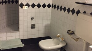 Ein Badezimmer mit Toilette, Bidet und Handtuchhalter.