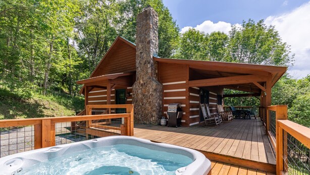 A cabin with a hot tub, wooden deck, and a stone chimney. - Silverleaf - 30 Mile View, Hot Tub, Close to ASU (Zionville)