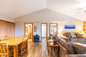 A spacious living area with a wooden dining table, a sofa, and a fireplace.