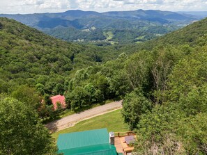 A cabin with a green roof, surrounded by dense forest and hills. - Silverleaf - 30 Mile View, Hot Tub, Close to ASU (Zionville)