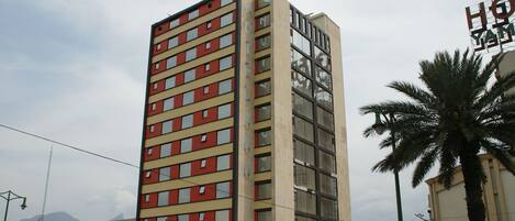 A tall hotel with multiple floors, large windows, and a visible sign for 'Hotel Yama'.