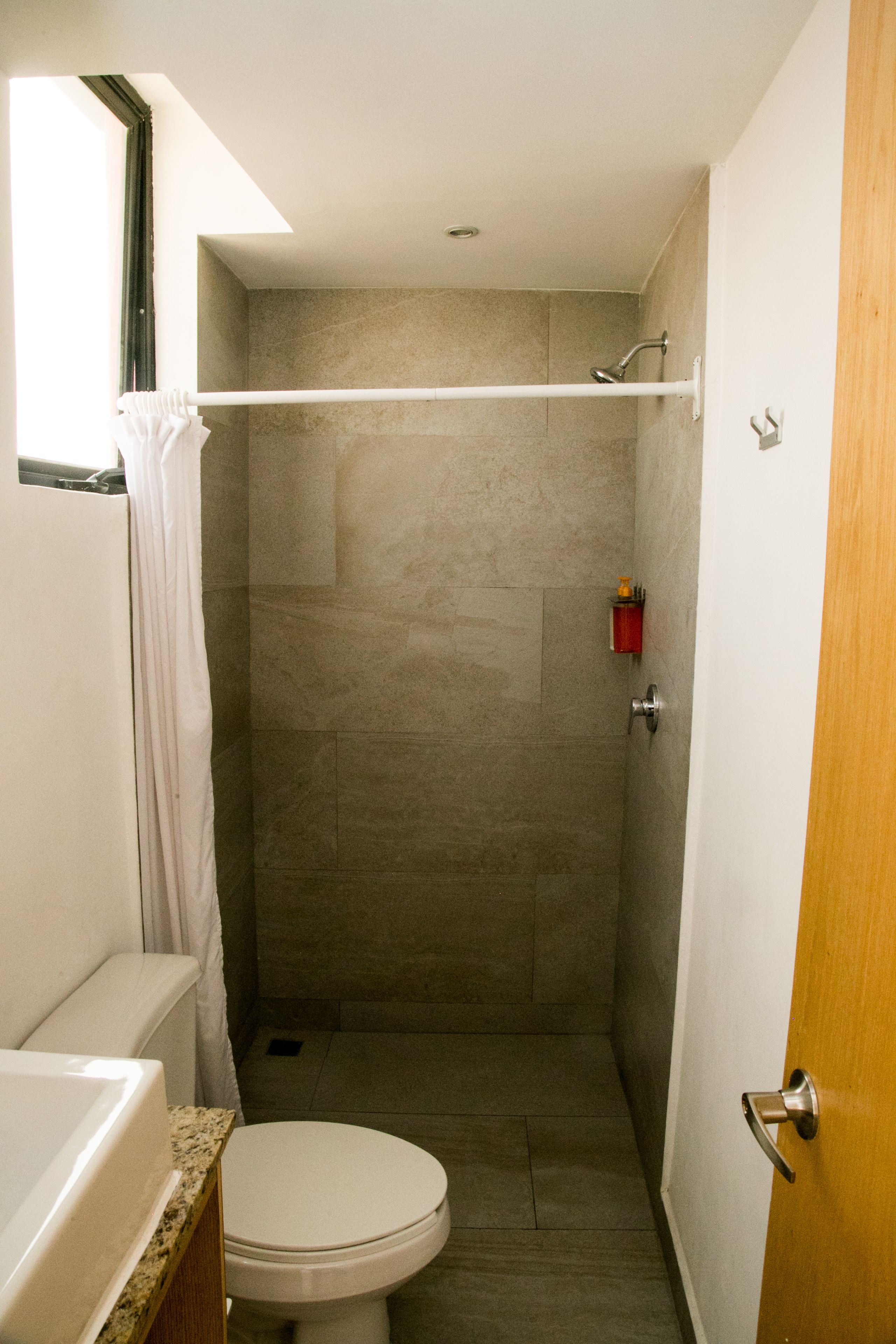 A small bathroom with a toilet, a shower, and a bathtub.