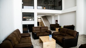 A spacious lobby with multiple seating areas, a staircase, and large windows. - Hotel 500 (Monterrey)