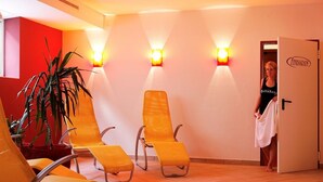 A room with yellow chairs, a potted plant, and a door labeled "Fitnessraum". - Hotel Wieser (Mittersill)