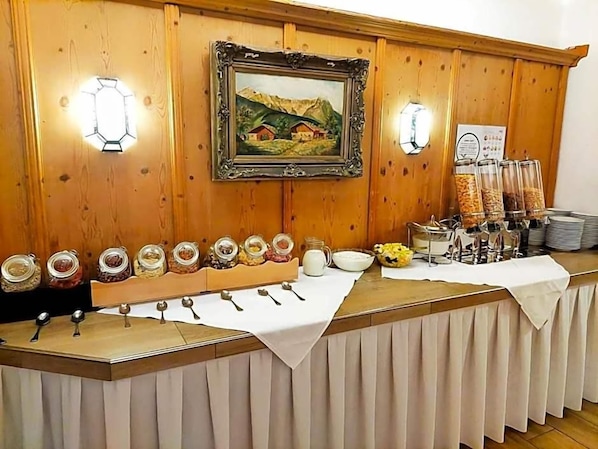 A buffet setup with various food items and utensils.