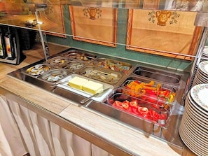 A buffet with various food items and condiments.