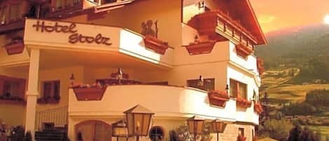A multi-story hotel with balconies and a sign reading 'Hotel Stolz.'
