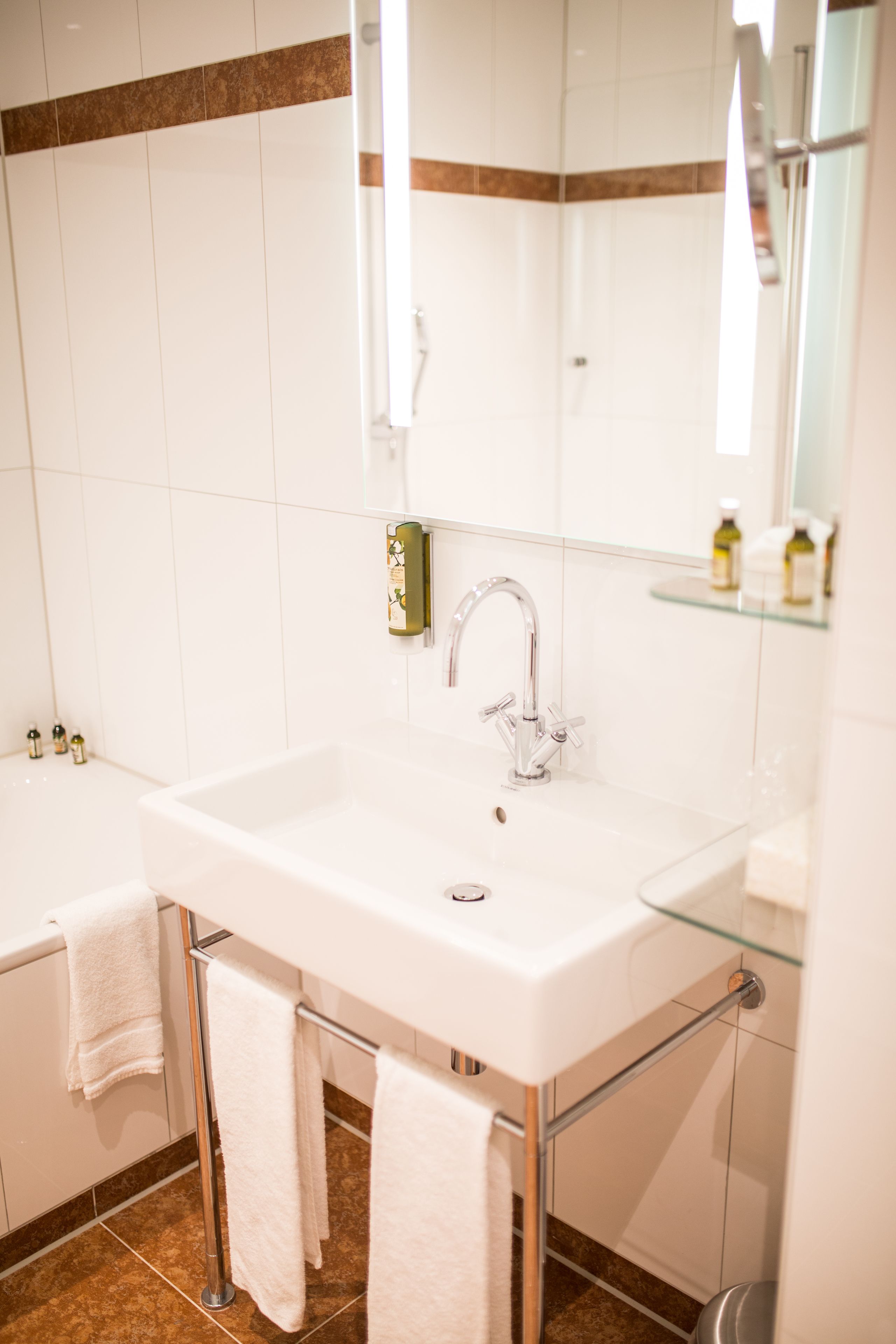 A bathroom with a white sink, a glass shower enclosure, and a white bathtub.