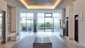 Un vestíbulo amplio con diseño moderno, que cuenta con un gran ventanal, una zona de estar y vistas al exterior.