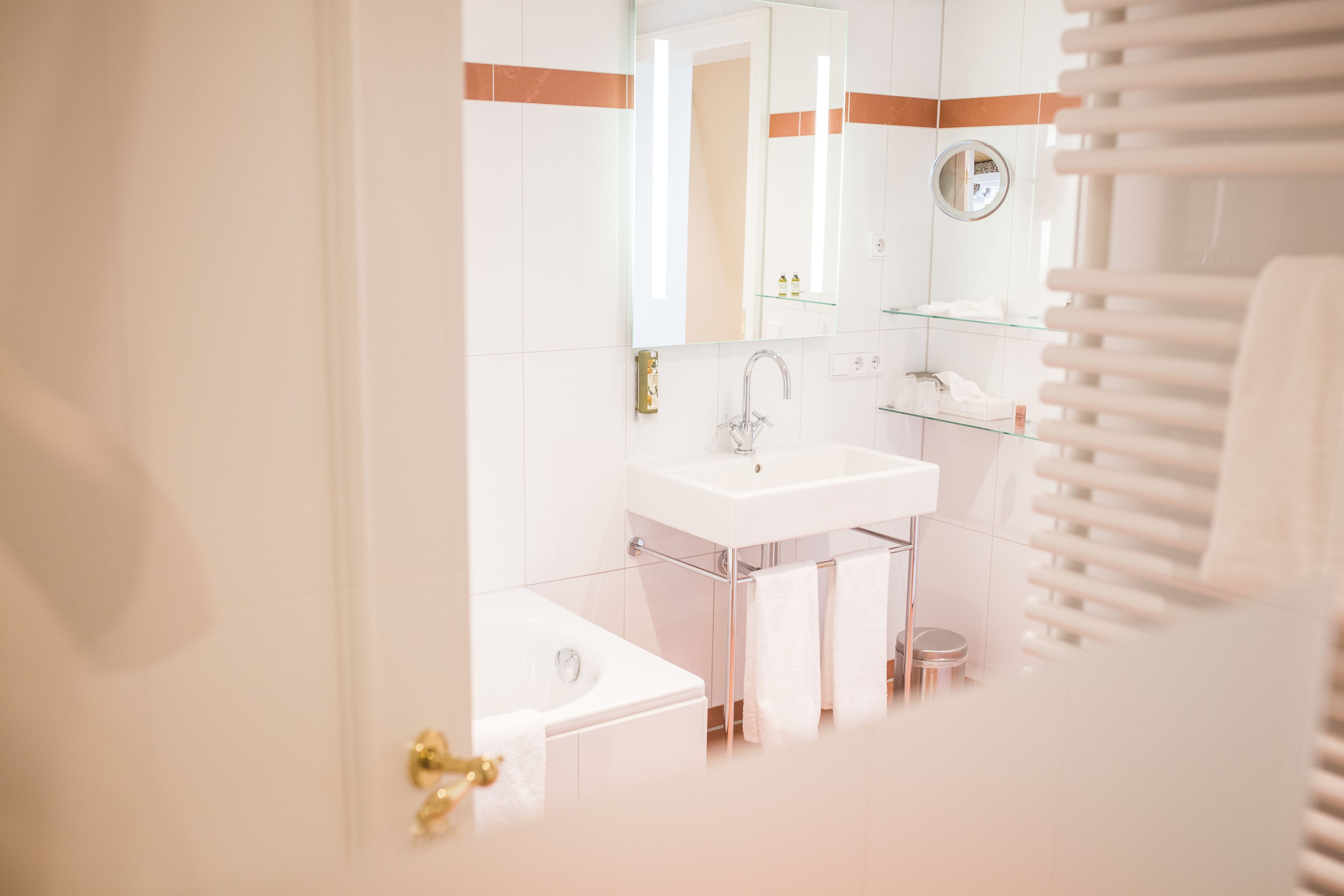 A modern bathroom with a white sink, a mirror, and a glass shower enclosure.
