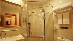 A hotel bathroom with a glass-enclosed shower, a sink, and a toilet. - Vienna Hotel (Shenzhen)