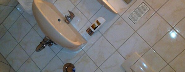 A bathroom with a sink, a toilet, and a bidet.