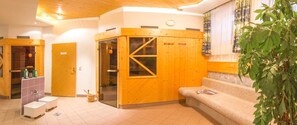 A sauna room with wooden walls, a glass door, and a bench.