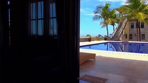 Ein Poolbereich mit Fußmatte, Palmen und einem Gebäude mit einer Treppe.