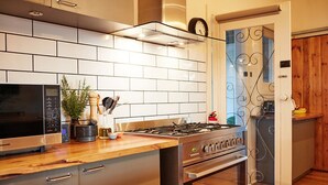 A modern kitchen with a stainless steel stove, a microwave, and a wooden countertop. - Yarra Valley Vineyard Cottage - premier location with spectacular views. (Gruyere)