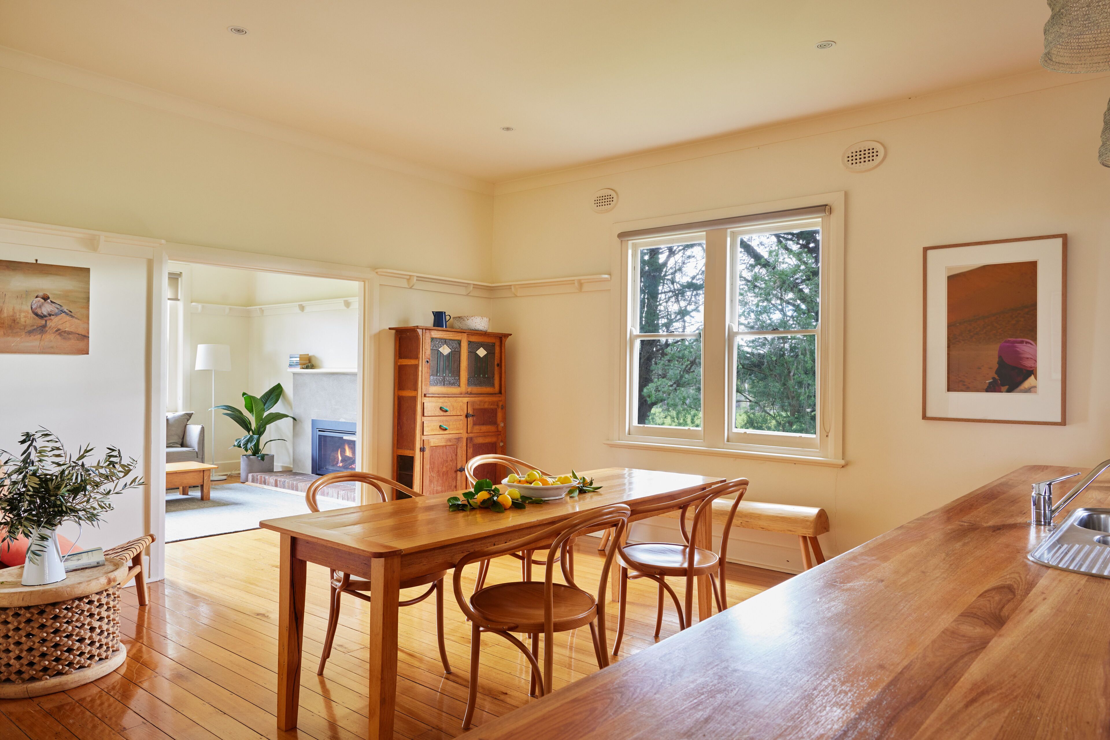 Una cocina amplia con una mesa de comedor de madera, sillas y un gran ventanal.