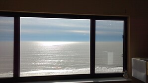 Una ventana con vista al océano y un cielo despejado.