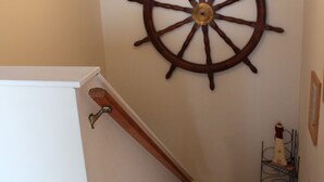 A wooden staircase with a ship's wheel mounted on the wall above it. - North Wildwood Townhouse, unit A. One Block To The Beach. Ocean Views From Deck. (North Wildwood)