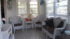 A room with white wicker furniture, including two chairs and a small table with a lamp. - North Wildwood Townhouse, unit A. One Block To The Beach. Ocean Views From Deck. (North Wildwood)
