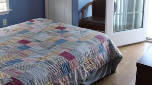A bedroom with a bed, a chair, a door, and a ceiling fan. - North Wildwood Townhouse, unit A. One Block To The Beach. Ocean Views From Deck. (North Wildwood)