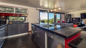 A modern kitchen with a large island, built-in appliances, and a view of the outdoors. - Stunning 3 bedroom en-suite house in farm with pool (Estoi)