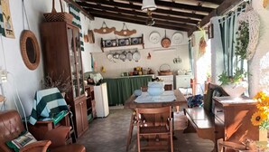 Un salon chaleureux avec une table en bois, des fauteuils en cuir et un sol carrelé.