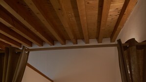 A bedroom with a wooden headboard, a bed with white linens, and a small rug on the floor. - bcube - bed and breakfast in the village (Pavia)