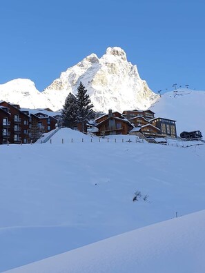 A snow-covered mountain with a ski resort in the foreground.