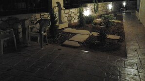 An outdoor patio area with stone steps, a small garden, and a chair. - father's house in kissamos (Korfalonas)