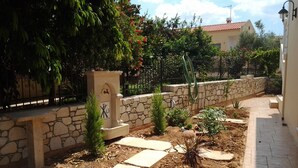 A garden with stone walls, small plants, and stepping stones. - father's house in kissamos (Korfalonas)