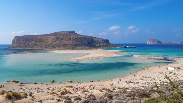 A coastal landscape with a large rock formation, clear blue waters, and a sandy beach. - father's house in kissamos (Korfalonas)