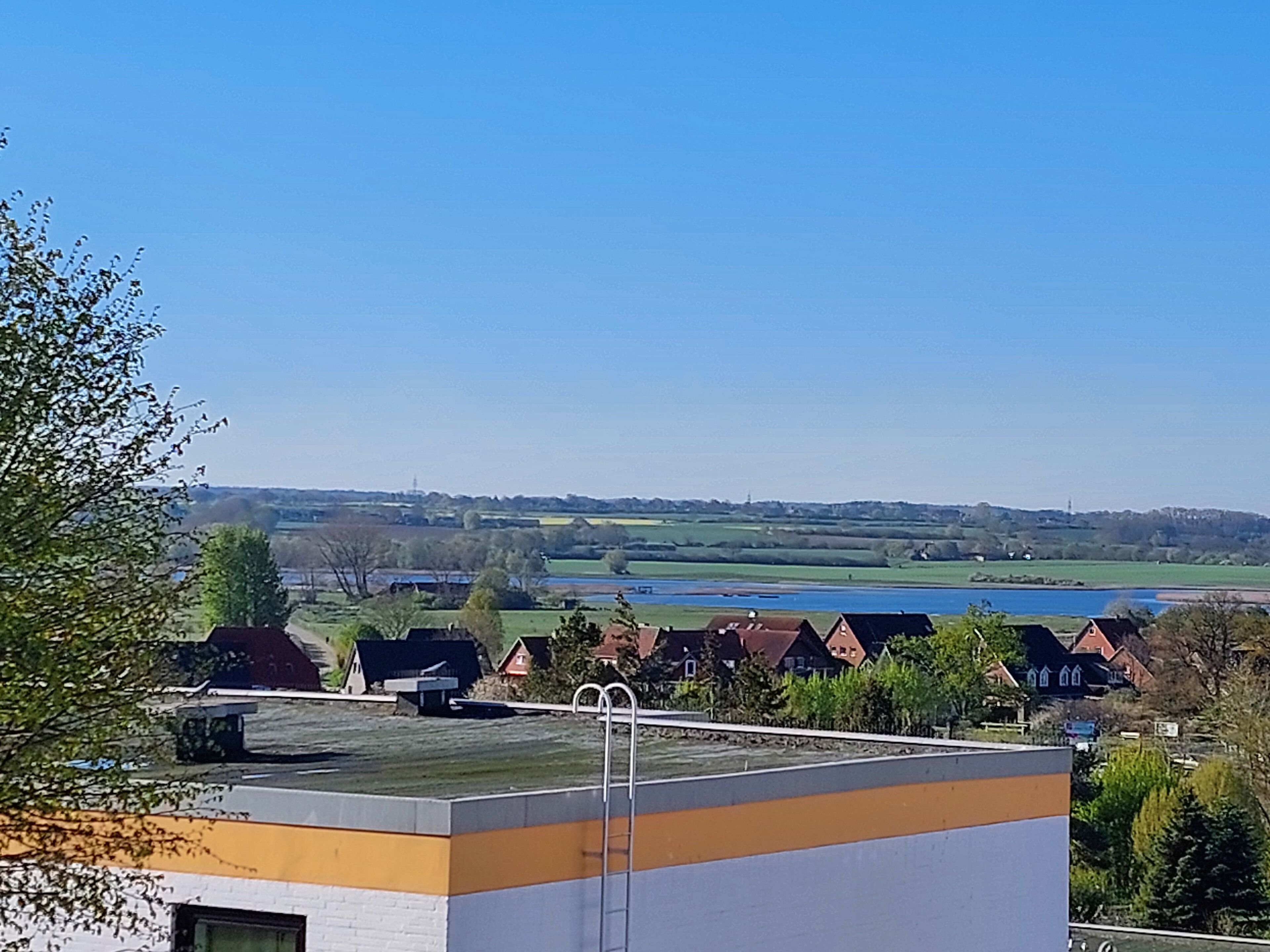 Un quartier résidentiel avec des maisons, un plan d’eau et un ciel dégagé.
