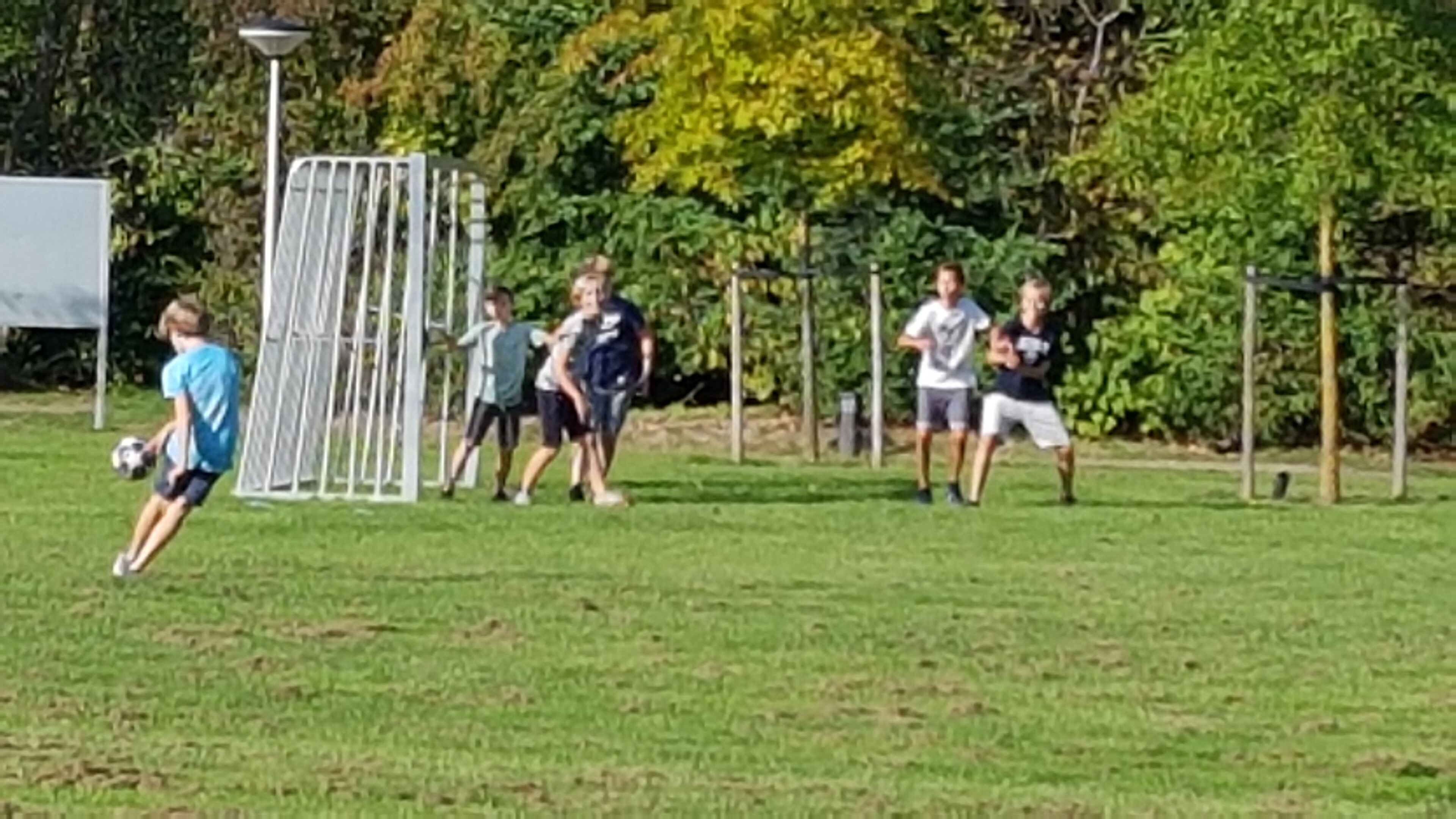Ein Fußballfeld mit Spielern und einem Tor.
