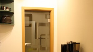 A small kitchenette with a coffee maker, a glass container, and a cabinet. - Cozy little apartment (Südwest)