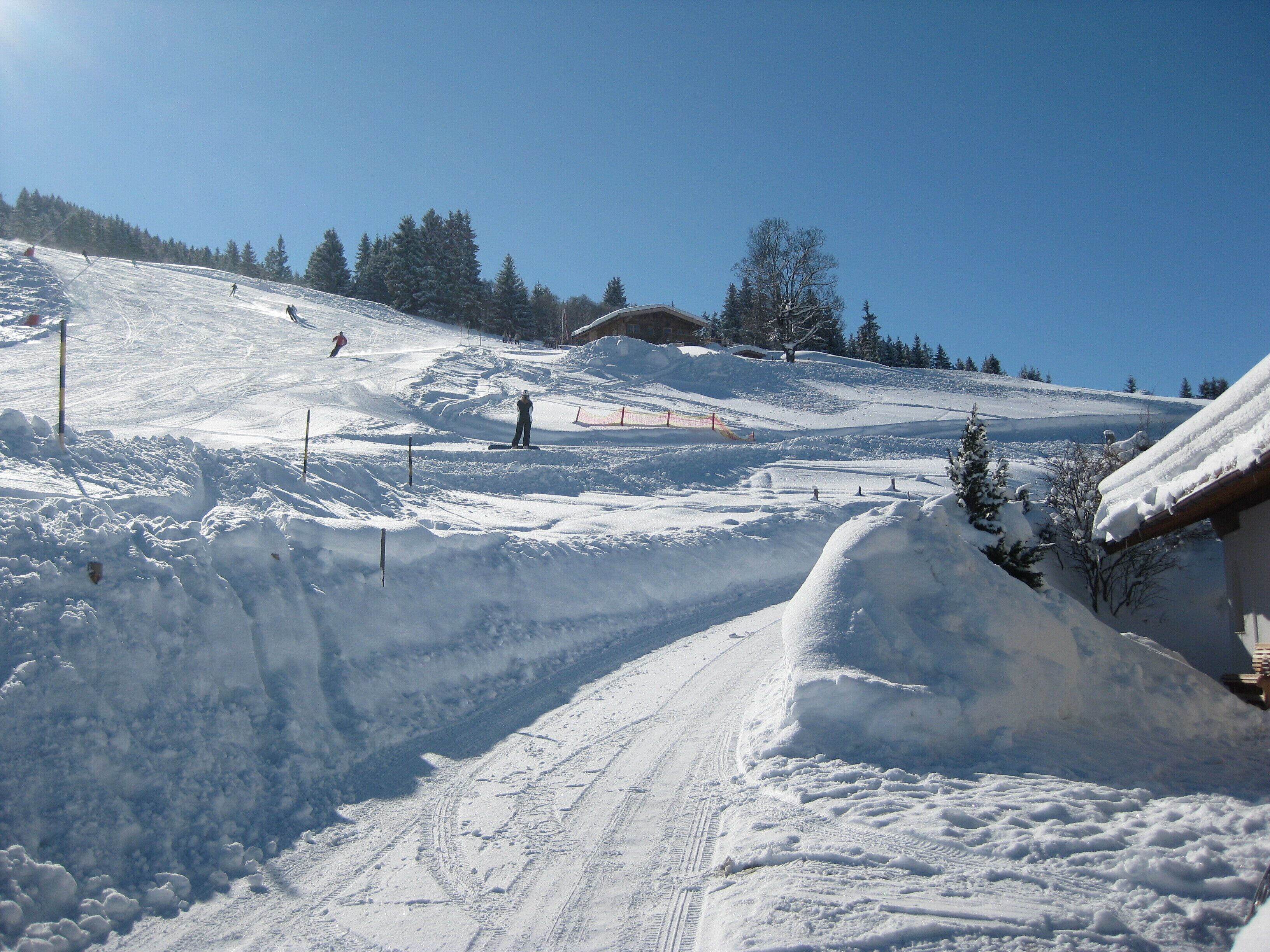 A snowy ski slope with a clear sky.