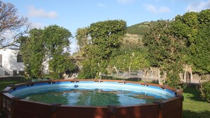 Ein Whirlpool, umgeben von üppiger Vegetation und einer Steinmauer.