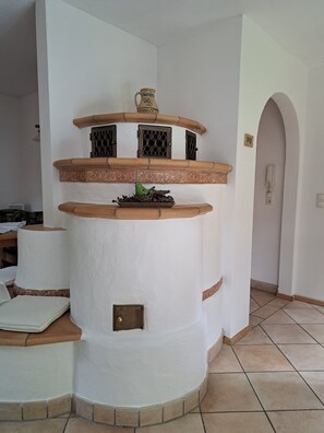 Una cocina con una isla central, un colgador de ollas y un salpicadero de azulejos.