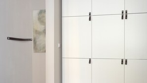 A white wardrobe with four doors and a single handle.