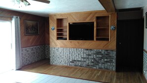 Ein Zimmer mit einer Holzausstattung, einer Wand in Ziegeloptik und einer Tür.