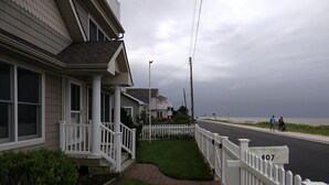Una calle residencial con casas, aceras y una vía.