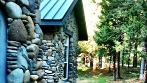 Una casa de piedra con una entrada circular y un pequeño jardín.