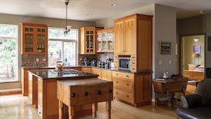Una cocina amplia con armarios de madera, una isla central y un comedor con mesa y sillas.