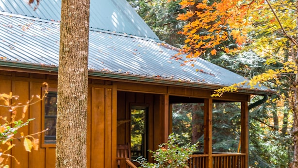 Une cabane en bois avec une véranda et un escalier en bois.