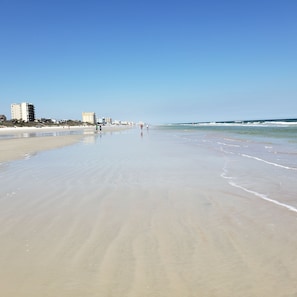 A wide sandy beach with a clear sky.