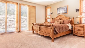 A bedroom with a wooden bed, a nightstand, a lamp, and a framed picture on the wall.