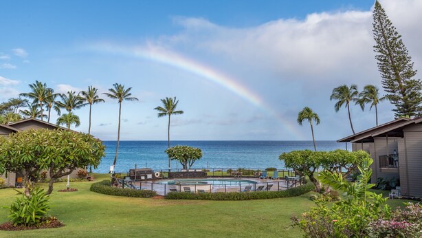 Ein Poolbereich mit Blick auf das Meer und einem Regenbogen.