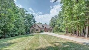 A two-story house with a stone facade, a front porch, and a well-maintained lawn.
