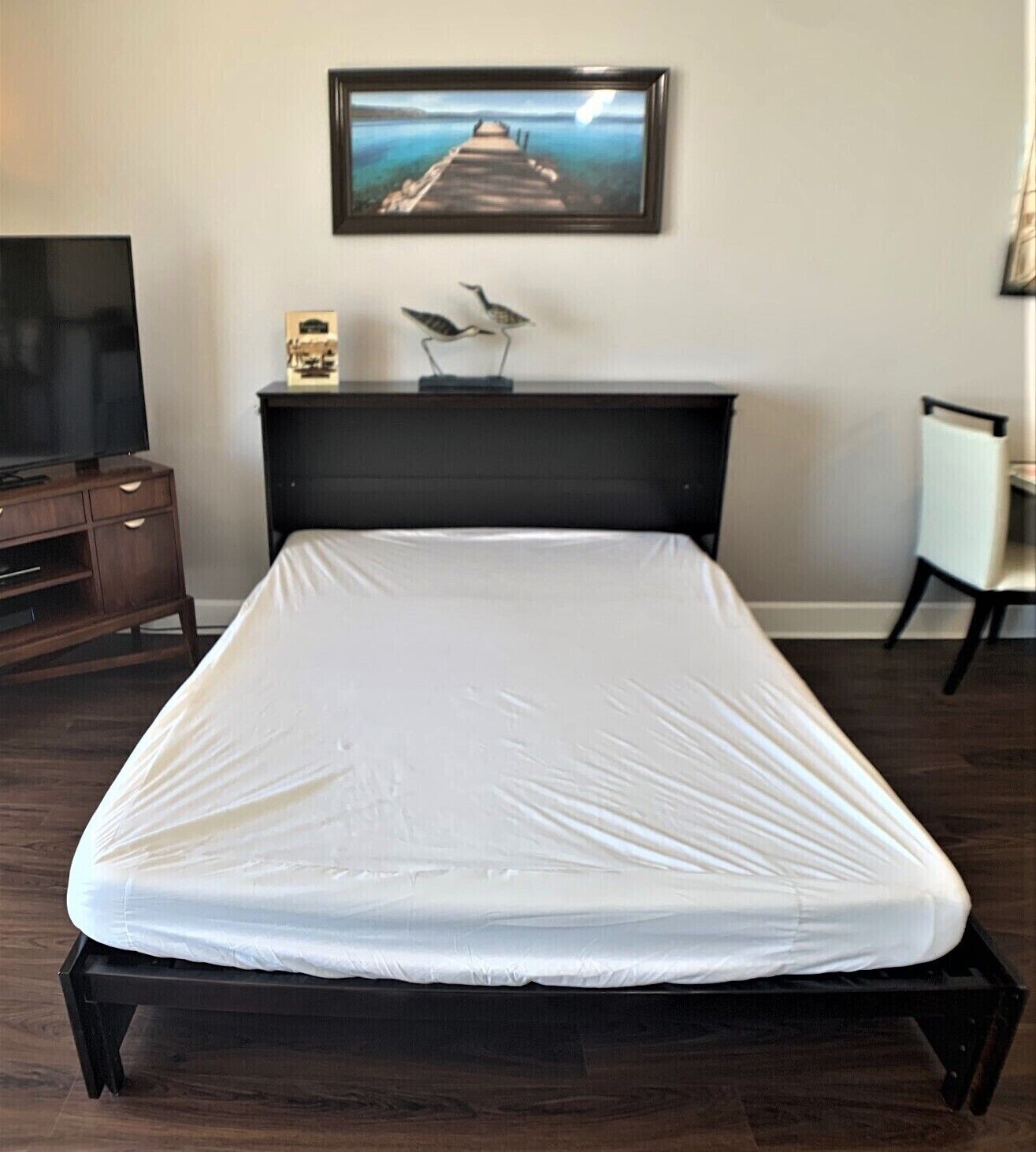 A neatly made bed with a white mattress in a hotel room.